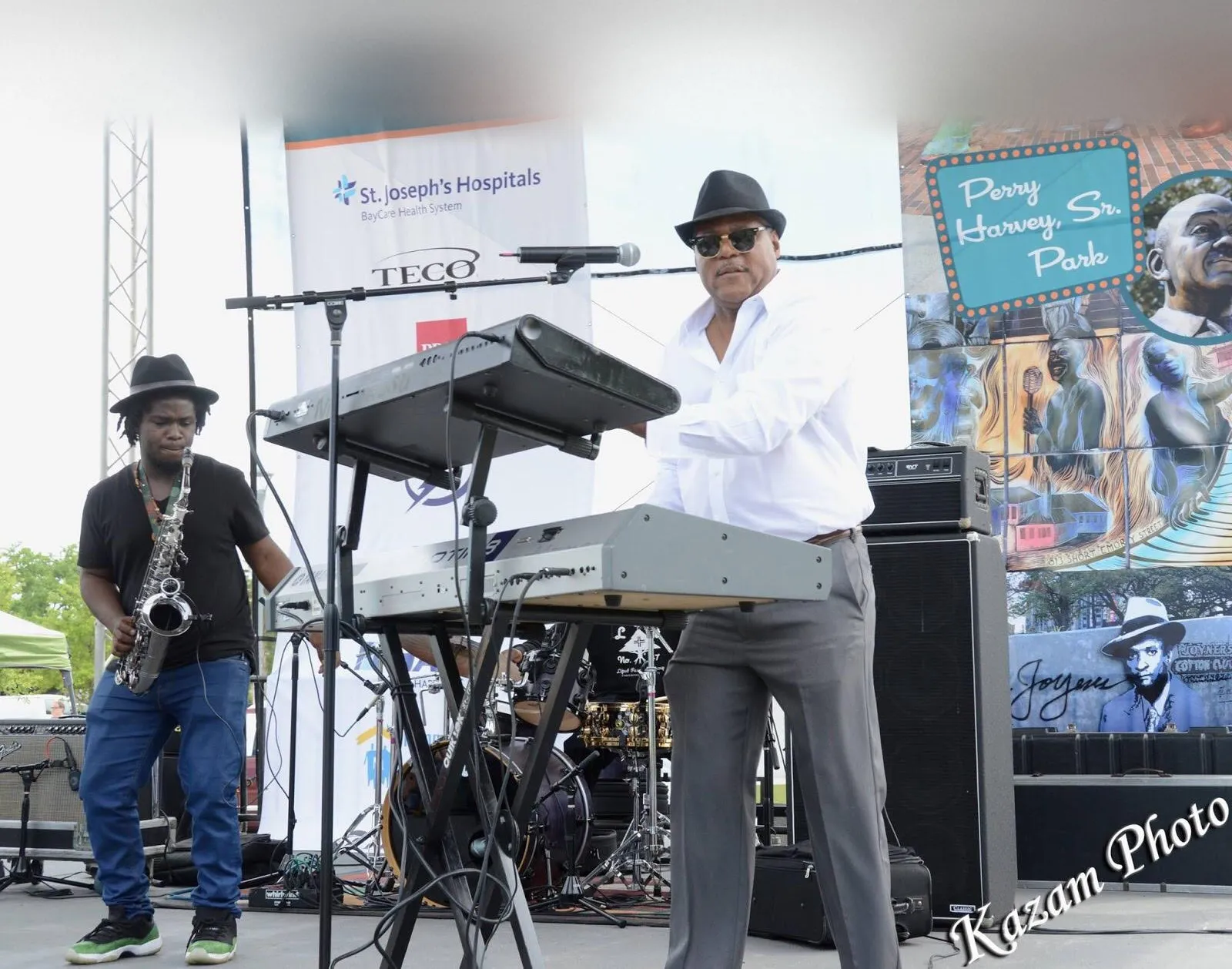 Shawn Brown performing on keyboards at an outdoor concert alongside a saxophonist